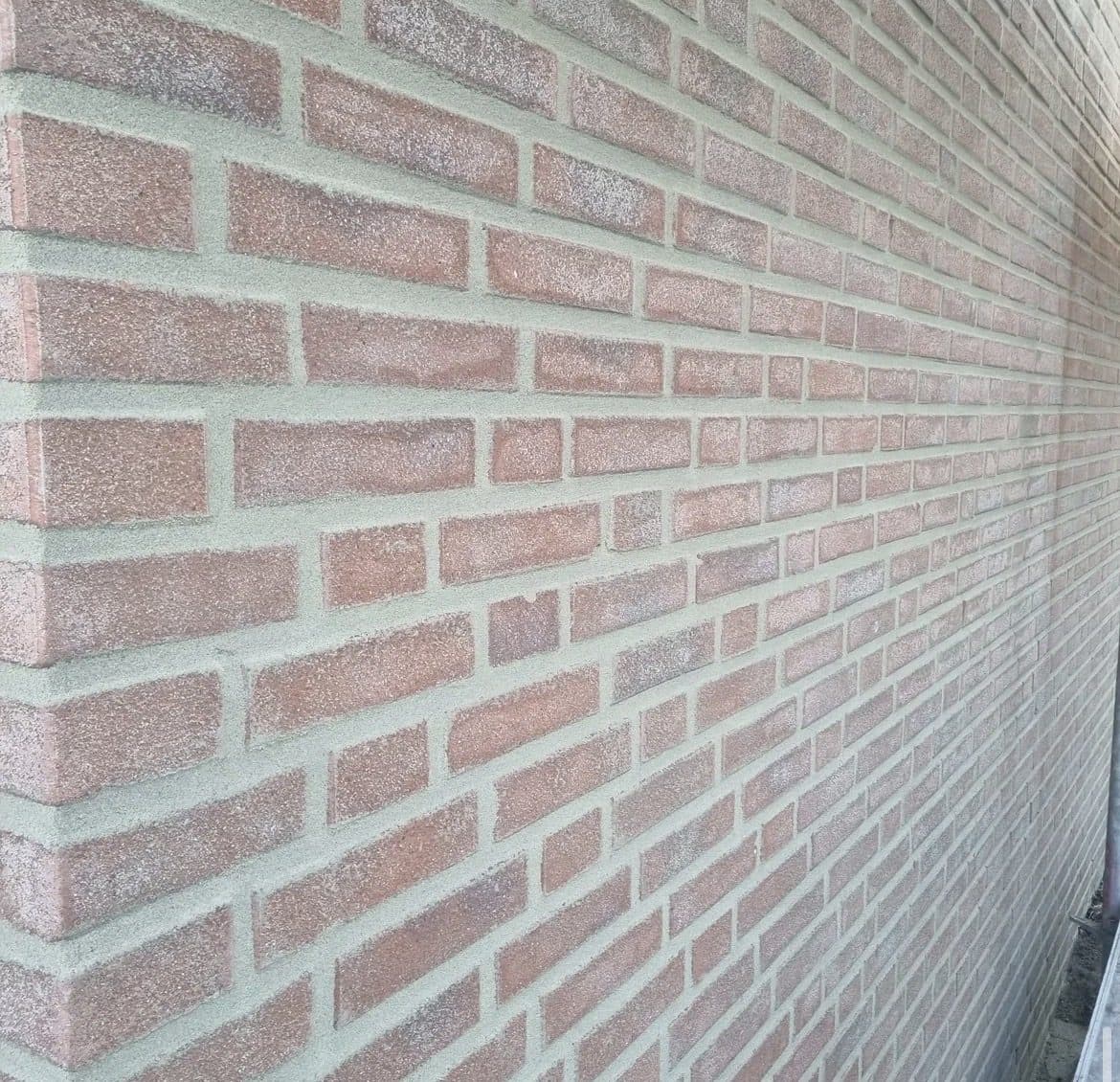 Macrodetail van strak, egaal voegwerk in een gevelhoek